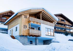 een huis in de sneeuw met een balkon bij Appartamenti Residence Pars in Badia