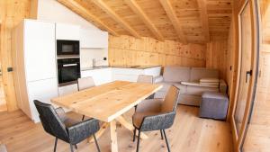 eine Küche und ein Esszimmer mit einem Holztisch und Stühlen in der Unterkunft Appartamenti Residence Pars in Abtei