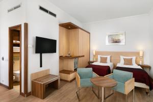 ブダペストにあるHotel Bristol Budapestのベッド2台とテレビが備わるホテルルームです。