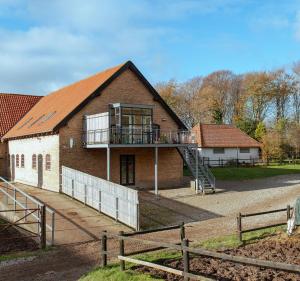 a building with a balcony on the side of it at Louiselund Bed & Breakfast in Haderslev