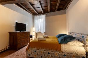 a bedroom with a bed with a television and a dresser at Maison di Lidia - Smart Holiday in Mantova