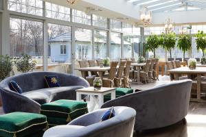 ein Restaurant mit blauen Stühlen, Tischen und Fenstern in der Unterkunft Farma Bii in Brzeziny