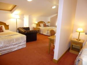 a hotel room with two beds and a couch at Cashen Course House in Ballybunion