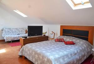 una camera da letto con un letto e una TV a schermo piatto di Lazy Lizard Studio a Seixal