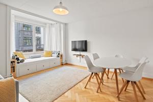 uma sala de estar com uma mesa e cadeiras e um sofá em Modern & Central Apartments em Lucerna