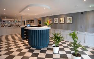 a lobby with a trash can on a checkered floor at The Lodge Hotel in Coleraine