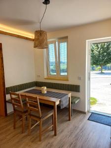 d'une salle à manger avec une table, des chaises et une fenêtre. dans l'établissement Gasthof Wachmann Ferienwohnung, à Weiz