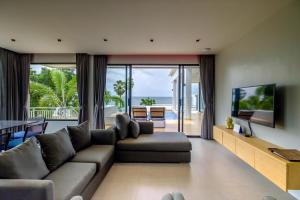 a living room with a couch and a television at Sunshine Paradise Resort in Ban Krut