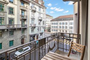 einen Balkon mit einer Bank und Straßenblick in der Unterkunft Modern & Central Apartments in Luzern
