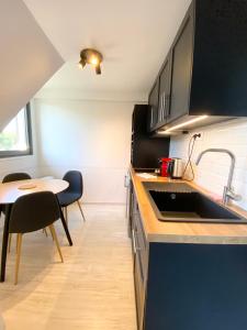 cocina con fregadero y mesa en L'OREE DE DEAUVILLE, CHARMANT DUPLEX PROCHE PLAGE, en Tourgéville