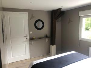 a bedroom with a white door and a mirror at Gîte le P'ti bonheur in Les Préaux