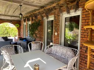 an outdoor patio with a white table and chairs at Lawendowa Przystań Sandomierska in Dwikozy