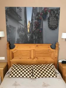 a bedroom with a bed with a wooden headboard and flowers at Maximiano Herculeo in Córdoba