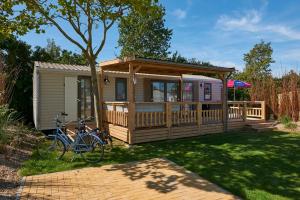 a cabin with a bike parked in front of it at Siblu Camping de Oase in Renesse