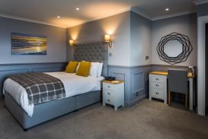 a bedroom with a large bed and a mirror at Kinloch Hotel, Isle of Arran in Blackwaterfoot