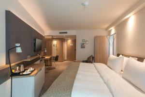 ein Hotelzimmer mit einem großen Bett und einem Schreibtisch in der Unterkunft Holiday Inn - Hamburg - Berliner Tor, an IHG Hotel in Hamburg