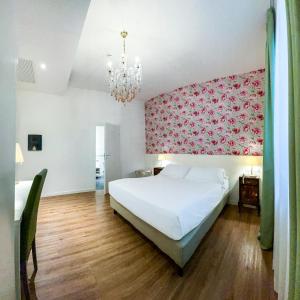 リミニにあるリミニ スイート ホテルのピンクの壁のベッドルーム1室(白いベッド1台付)