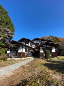 una casa en una colina con una entrada de grava en 1日1組限定-伊那谷別邸-share old folk house-, en Ina