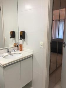 a white bathroom with a sink and a mirror at Resort In Mare Bali - Apto lado da sombra in Parnamirim