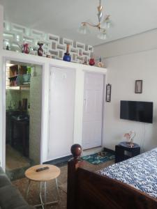 a bedroom with a bed and a table and a tv at RAFIKI Apartment in Mombasa