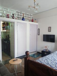 a bedroom with a bed and a tv and a table at RAFIKI Apartment in Mombasa