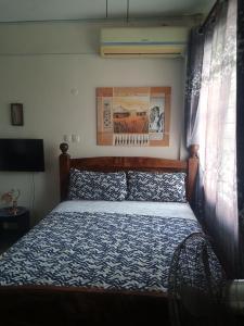 RAFIKI Apartment في مومباسا: غرفة نوم مع سرير مع لحاف أزرق