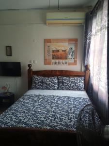 a bedroom with a bed with a blue comforter at RAFIKI Apartment in Mombasa