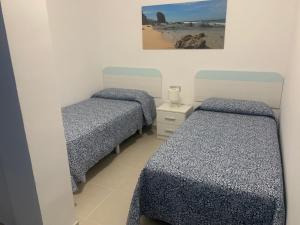 sypialnia z 2 łóżkami i zdjęciem plaży w obiekcie Apartamentos Tao Noah w mieście Puerto del Rosario