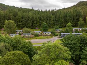 arial view of a village in the mountains with trees at Loch Broom Cabins Seaviews& Petfriendly in Leckmelm