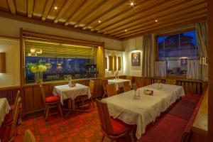 Hotel zur Flüh في باد ساكينغن: مطعم بطاولتين وكراسي ونافذة