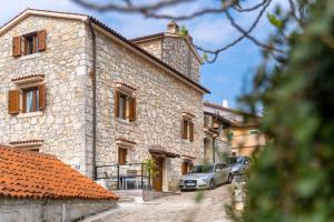 a stone building with a car parked in front of it at Luxury 3 Bedroom Apartment in Vrsar
