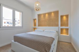 a white bedroom with a bed and a window at Amazing views of Alghero old town and the sea in Alghero