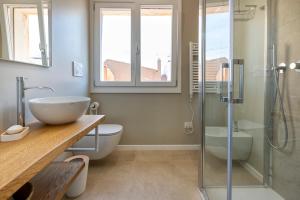 ein Badezimmer mit Waschbecken und Glasdusche in der Unterkunft Amazing views of Alghero old town and the sea in Alghero + 13 Fotos