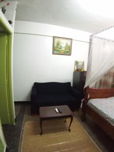 SAFI Apartment في مومباسا: غرفة معيشة مع أريكة وطاولة قهوة