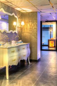 a bathroom with two sinks and a large mirror at Alpenlove - Adult SPA Hotel in Seefeld in Tirol