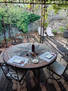 a circular table with chairs and a bottle of wine at Domaine Les Cascades in Ribaute