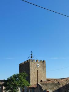 a clock tower with a cross on top of a building at Domaine Les Cascades in Ribaute
