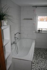 a white bath tub in a bathroom with a window at Frey - Ferienhaus über zwei Etagen mit Terrasse in Eggebek +10 photos