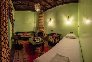 a bedroom with a bed and a room with a fireplace at Riad Omar in Marrakesh