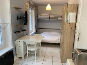 eine kleine Küche mit einem Tisch und einem Etagenbett in der Unterkunft Joli Studio proche plage et centre avec parking in Wimereux