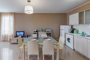 una sala da pranzo con tavolo e sedie e una cucina di Apartments at Lighthouse Golf by Parnas Estate a Balchik