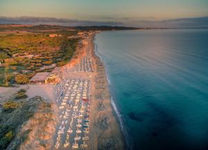 una vista aerea di una spiaggia con ombrelloni e acqua di Camping Golfo dell'Asinara a Platamona