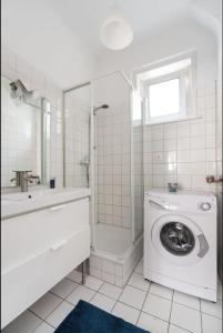 a white bathroom with a washing machine and a shower at City Center Operastreet Apartment "Italy" in Vienna