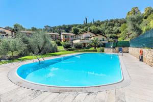 a large swimming pool in a yard with houses at Al Vittoriale 3 by Wonderful Italy in Gardone Riviera
