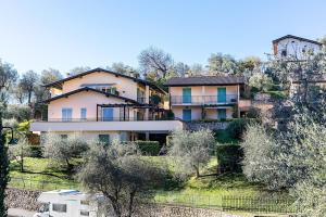 una casa grande en la cima de una colina con árboles en Al Vittoriale 3 by Wonderful Italy, en Gardone Riviera