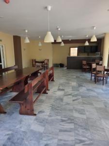 a large room with a large wooden table and chairs at Семеен хотел Чекръка in Iskŭr