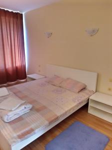 a bedroom with a large bed with a blue rug at Семеен хотел Чекръка in Iskŭr