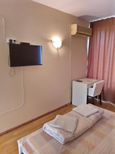 a room with a bed with a tv on the wall at Семеен хотел Чекръка in Iskŭr