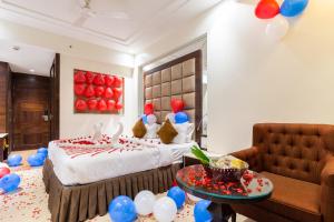 a hotel room with a bed with balloons on the wall at Amara Grand Inn Calangute in Calangute
