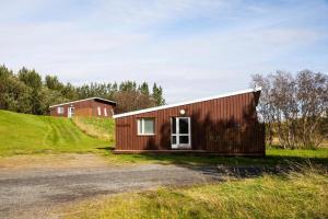 a small wooden building on a grassy hill at Skálholt Cottages in Selfoss